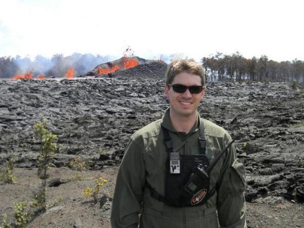 USGS scientist Wes Thelen standing in front of lava fountaining during and eruption from Kilauea volcano. 