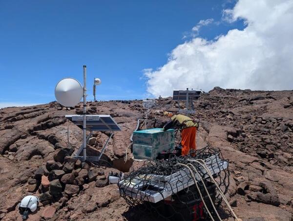 Color photograph of person working on monitoring equipment in the field