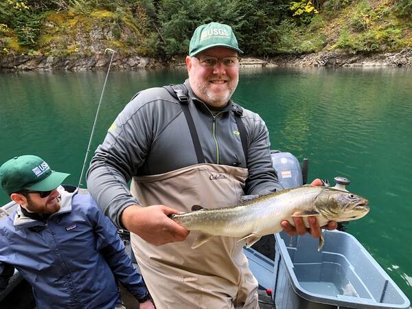 scientist holding fish on boat