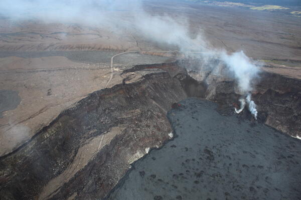 Color photograph of steaming vents within a caldera