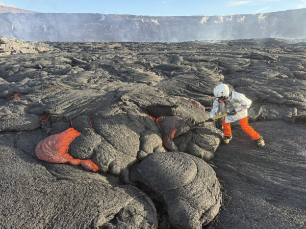 Color photograph of lava sample being collected