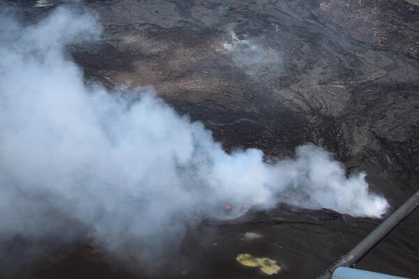 Color photograph of degassing vent with a tiny amount of incandescent lava visible within it