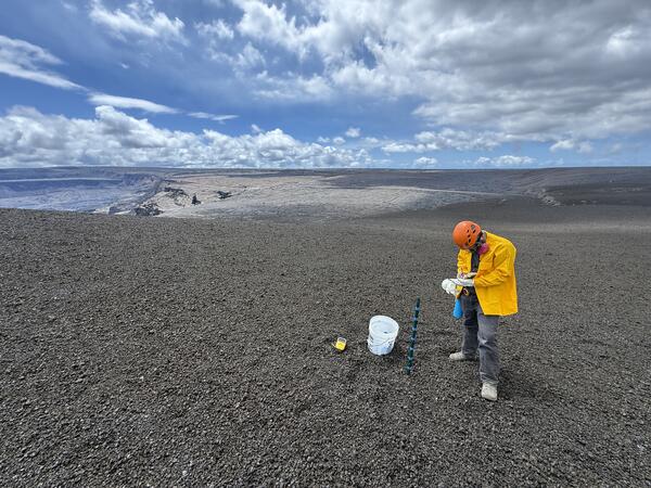 Color photograph of scientist near bucket
