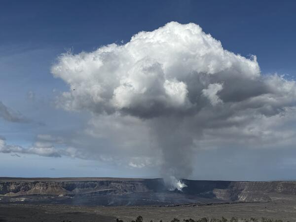 Color photograph of volcanic crater with degassing plume rising above it