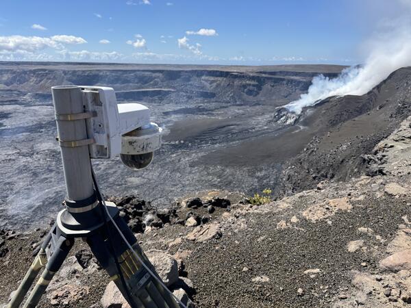 Color photograph of volcano monitoring webcam overlooking volcanic crater with degassing vent