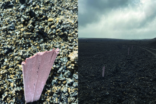 Color photograph of damaged post in fragmented material; posts along road of fragmented material