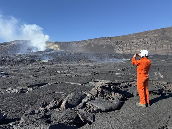Color photograph of scientist documenting a volcanic vent