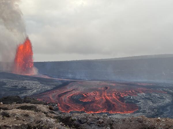 Color photograph of lava fountain and lava flow within crater
