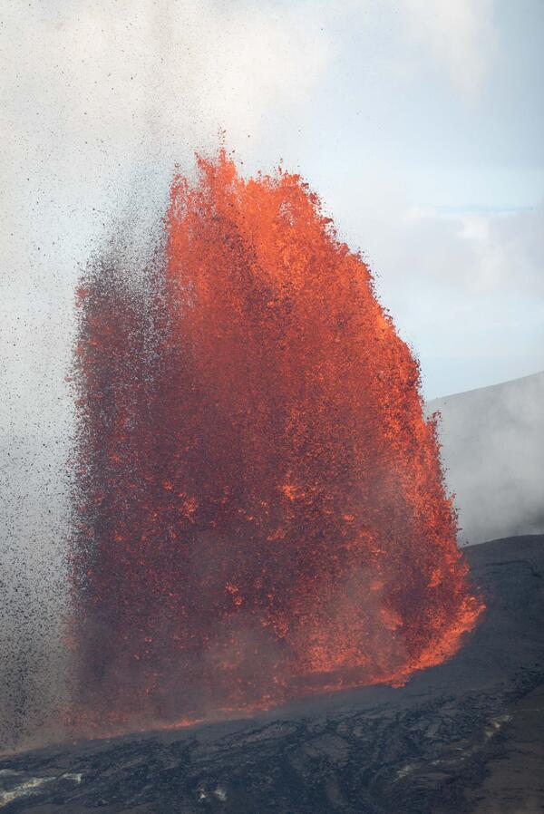 Color photograph of lava fountain erupting during the day