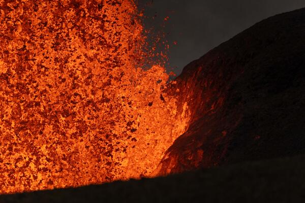 Color photograph of lava fountain base next to cone at night
