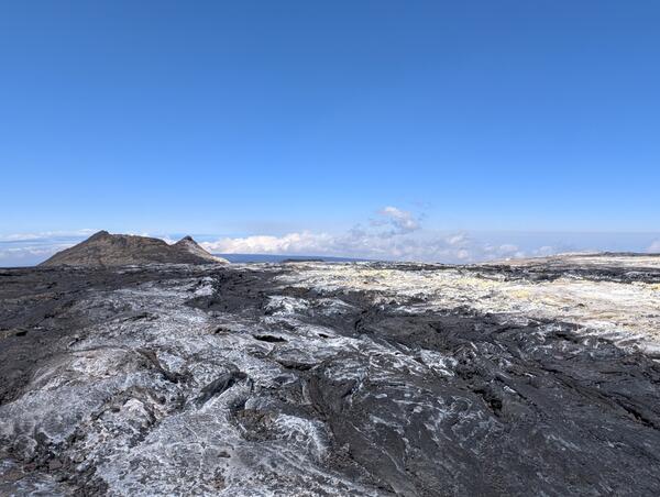 Color photograph of volcanic vent with sulfur deposits surrounding it