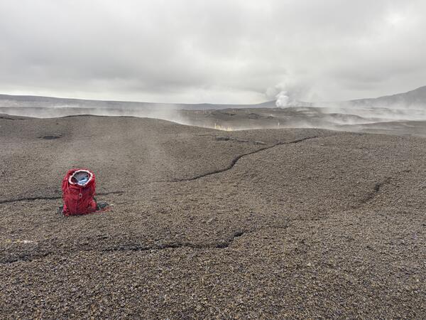 Color photograph of backpack next to crack