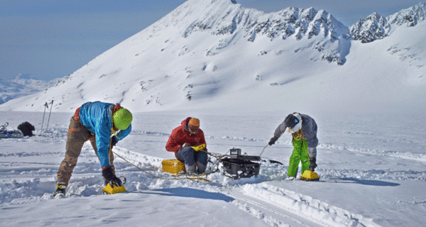 Three USGS researchers use ground penetrating radar to determine the depth of the snow on Wolverine Glacier, AK