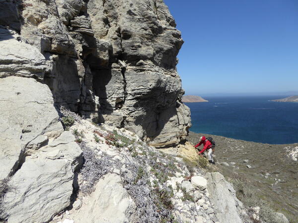 Geologist standing on steep outcrop on island