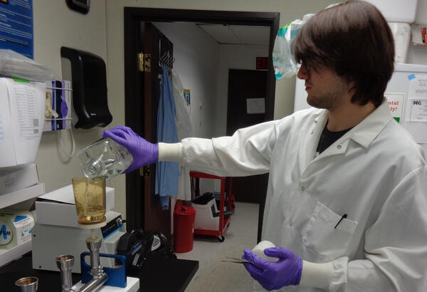 A USGS microbiologist pours a groundwater sample into a sterile filter cup