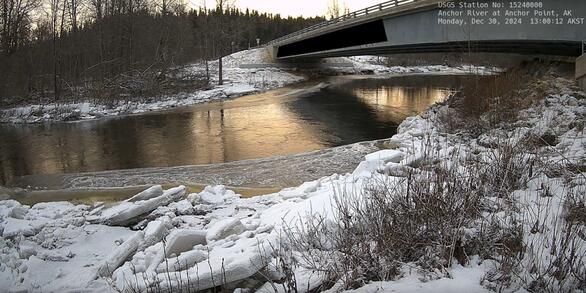 View of Anchor River in Alaska from the riverbank with the road bridge in the background.