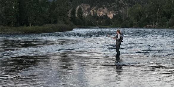 Person fly-fishing in a river