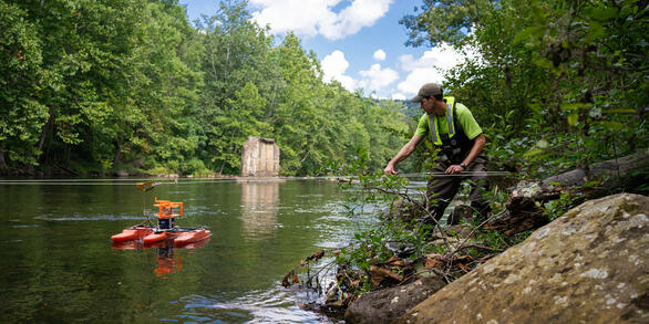 Eric Boyd pulls an Acoustic Doppler Current Profiler across a river.