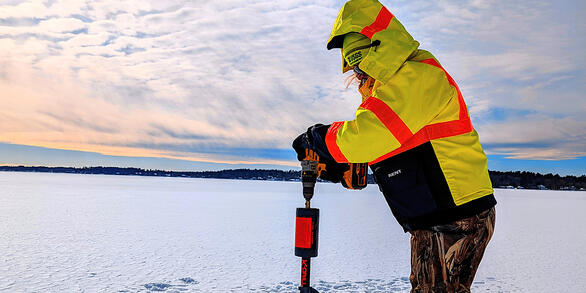 Technician bores a hole in a frozen lake to take water quality samples on Long Pond, Lakeville, MA.