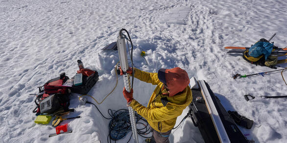 A scientist prepares to extract a snow core from one of the Benchmark Glaciers.  