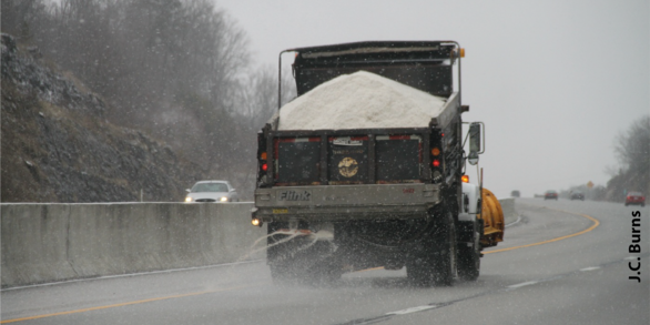 Truck distributing road salt on a highway