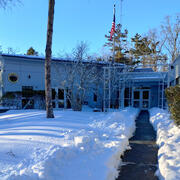 building with lots of snow on the ground and a shoveled path to the door