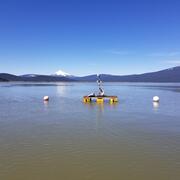 floating platform on upper Klamath Lake. Blue sky over lake water with distant snow capped mountain
