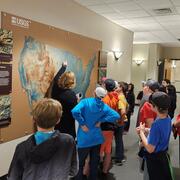 USGS tour guide points at a map on the wall