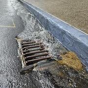Water flows into drain in pavement
