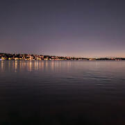 skyline at night with lots of artificial light from houses and buildings along the lake
