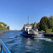 A research vessel moves through a channel toward Lake Michigan