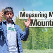 Thumbnail image of a man standing outside holding up his hands and speaking in front of a forest