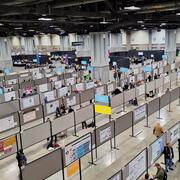 An aerial view of posters hanging in a convention hall.
