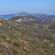 vegetation covered mountains in the image foreground and background