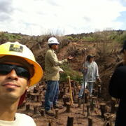 A man in safety gear takes a picture of himself with his crew.