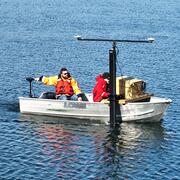 two people in small boat on pond