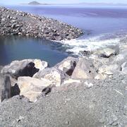 A rocky causeway divides the waters of the Great Salt Lake, with distinct color variations visible between the north and sout