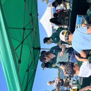 Person in USGS shirt talking to adult and two kids at USGS booth outside