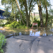 A river overflows into a parking lot.