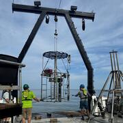 Three people on deck of ship working with mega multicorer