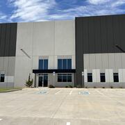 large, new building with blue sky in the background. The building is white, tan, and brown.