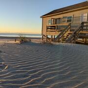Sky, ocean, sandy beach, and house on beach