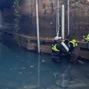 Scientists installing sensor in river