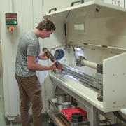 Scientist placing a sediment core in the rotating x-ray computed tomography system