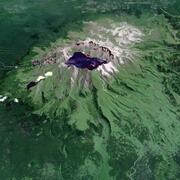 Satellite image of a volcano crater filled with a lake and green vegetation down much of the sides
