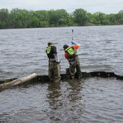 Three USGS Scientists deploying equipment on flooded pier in Delaware River