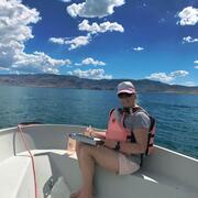 Phaedra Budy sitting on a boat on a Utah lake
