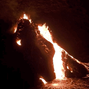 Lava bubbling out of a fissure at night time.