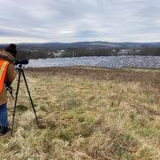 Graduate student is researching birds at a solar field.