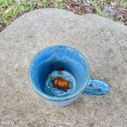 blue pottery mug with orange pond turtle